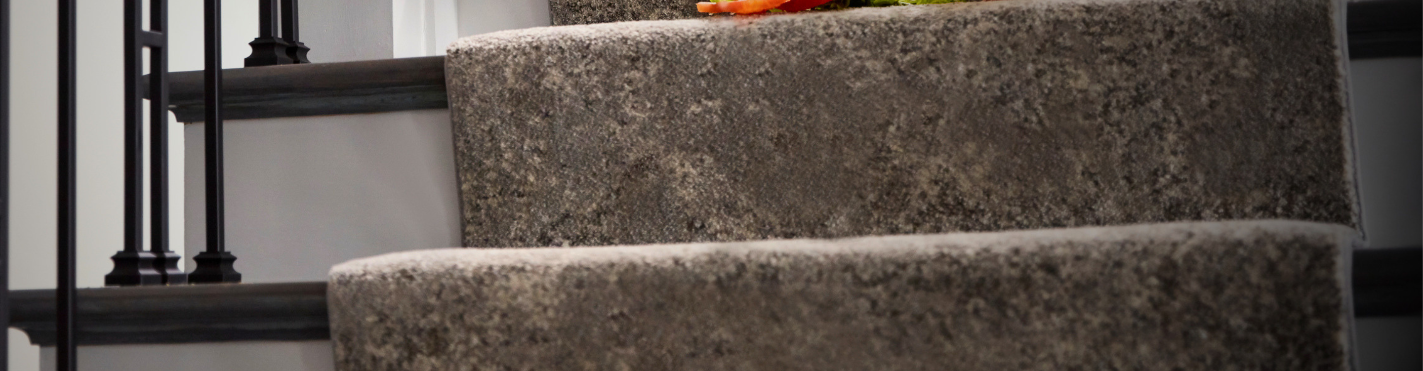 custom gray stair runner on wooden stairs with iron railing